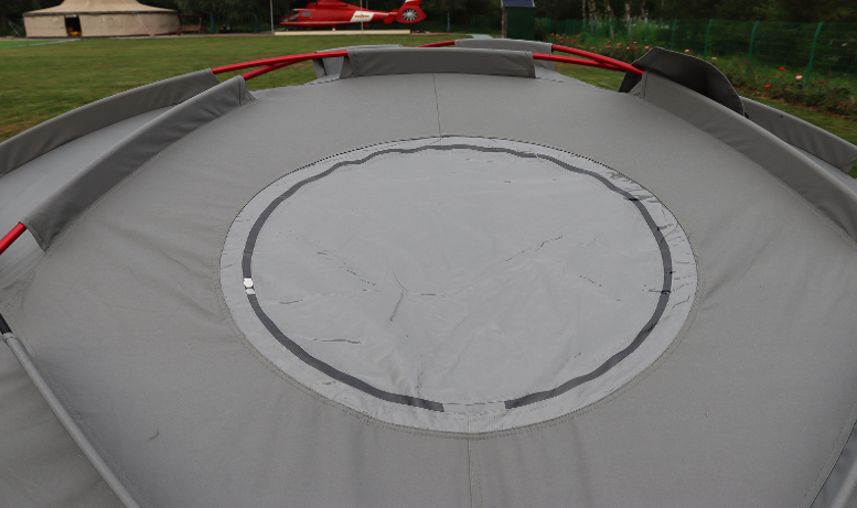 Trampoline with a circular design on a grassy field